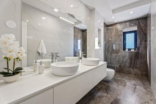 uma casa de banho branca com 2 lavatórios e um chuveiro em NEW! Villa Lukas with 44m2 pool in Makarska hinterland em Gornji Vinjani