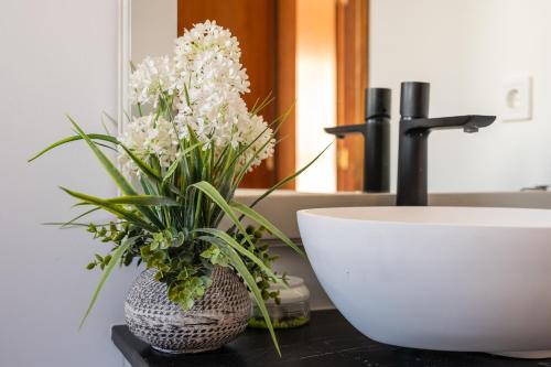a bathroom with a sink and a vase with flowers at Brisa del mar in Chilches