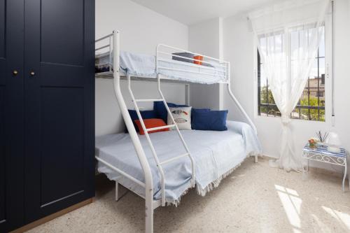 a bedroom with a bunk bed and a window at Brisa del mar in Chilches