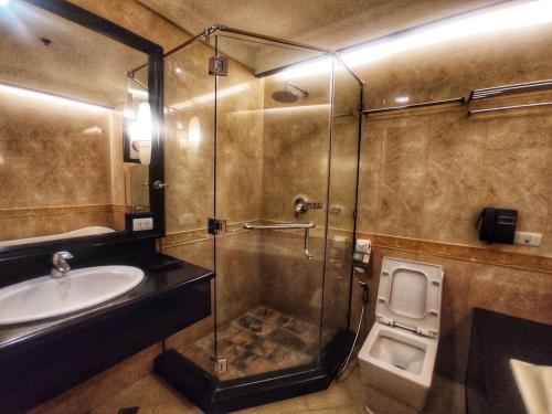 ein Bad mit einer Dusche, einem Waschbecken und einem WC in der Unterkunft Romantic 1BR Fields Plaza 401 Hotel by ABC, instant booking now in Angeles