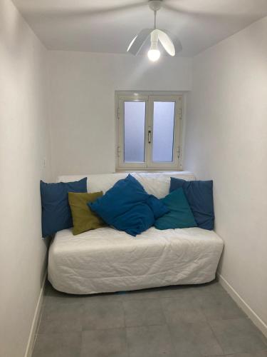 Sofá blanco con almohadas azules en una habitación en Casa Cavour 153, en Cori