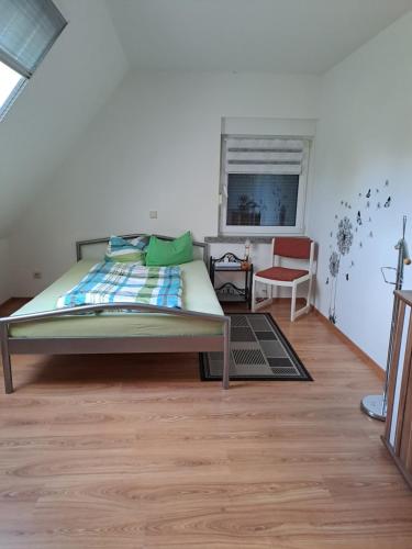ein Schlafzimmer mit einem Bett, einem Stuhl und einem Fenster in der Unterkunft Monteur- und Ferienwohnung im Obergeschoss und Dachgeschoss - Familie Weber in Bockendorf