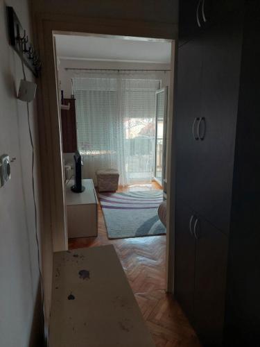 a hallway with a door to a room with a window at Apartman Uki in Vranje