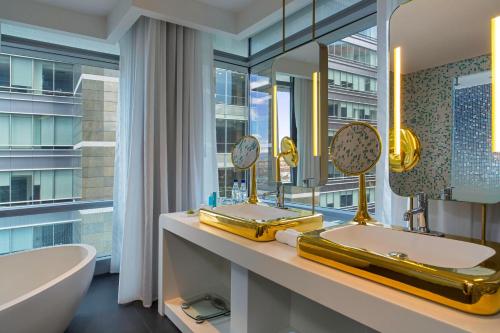 a bathroom with a tub and a sink and a mirror at W Bogota in Bogotá