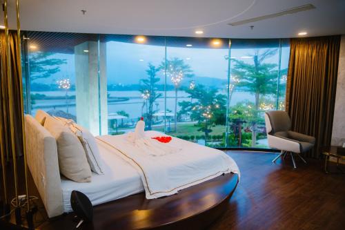 ein Schlafzimmer mit einem Bett und einem großen Fenster in der Unterkunft Mr. Boss House Apartment in Đà Nẵng
