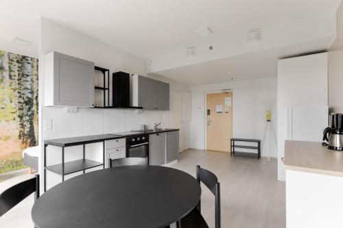 a kitchen and dining room with a table in it at Serviced Apartments Kuohu Kangasala by UHANDA in Kangasala