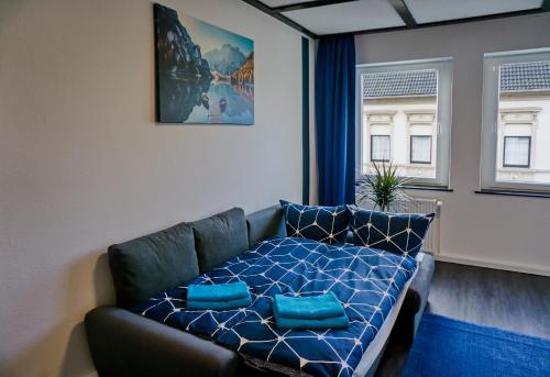 sala de estar con sofá y almohadas azules en BIG Apartment bis 7 Personen, en Solingen