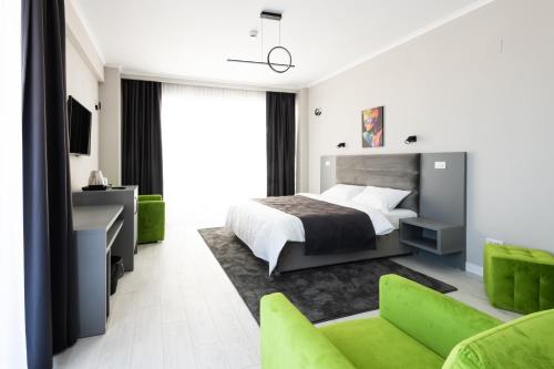 um quarto com uma cama e um sofá verde em Hotel Javu em Mamaia Nord – Năvodari