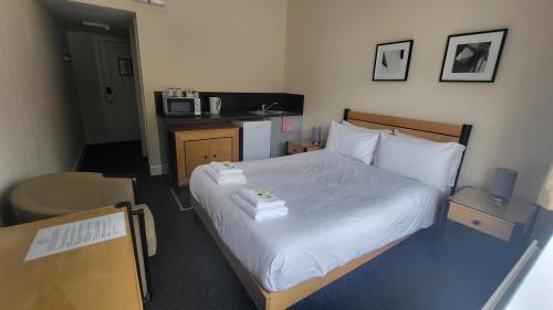 a bedroom with a bed with two towels on it at The Earlham Hotel in Norwich