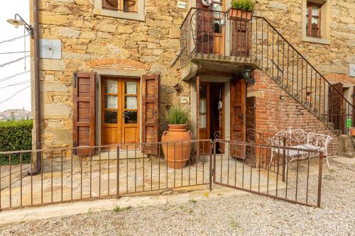 a building with a gate in front of a building at Borgo Dolci Colline Resort Ziraia in Castiglion Fiorentino