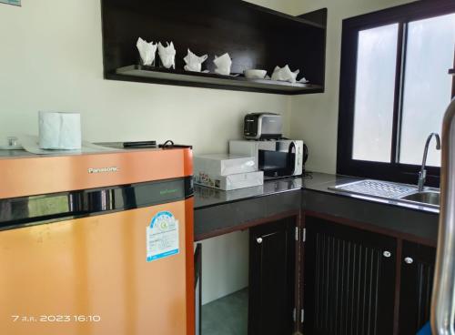 una cucina con frigorifero arancione e forno a microonde di Garto Resort a Ko Samui