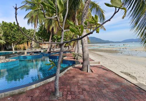 una piscina con palme sulla spiaggia di Garto Resort a Ko Samui
