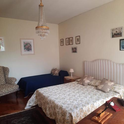 a bedroom with a bed and a chandelier at Villa dei Gelsomini, Residenza nel verde in Viterbo