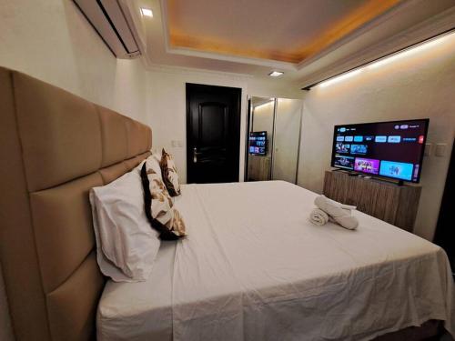 ein Schlafzimmer mit einem großen Bett und einem TV in der Unterkunft 1BR Fields Plaza Hotel 402 by ABC near to walking St in Angeles