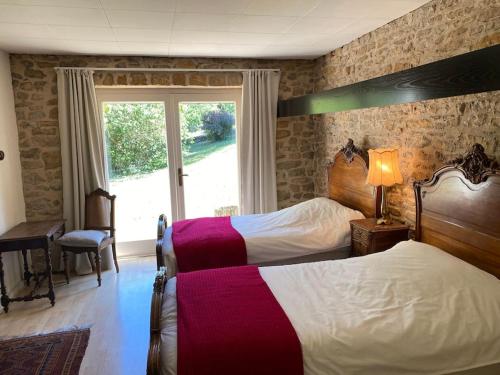 ein Hotelzimmer mit 2 Betten und einem Fenster in der Unterkunft Calme et tranquillité à la campagne in Charnay