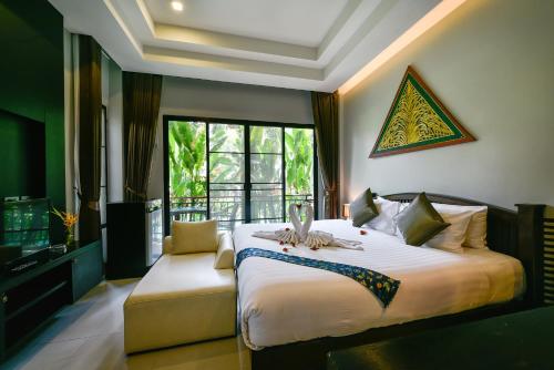 a bedroom with a large bed and a window at Coco Retreat Phuket Resort and Spa - SHA Plus in Chalong 
