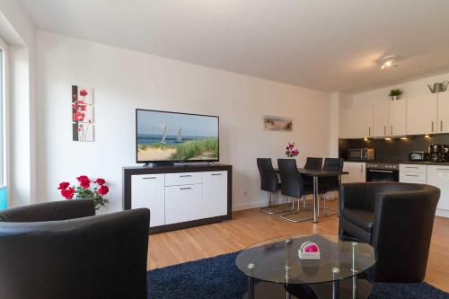 レリクにあるFerienwohnung Ostseebrise Rerikのテーブルと椅子、キッチンのあるリビングルーム