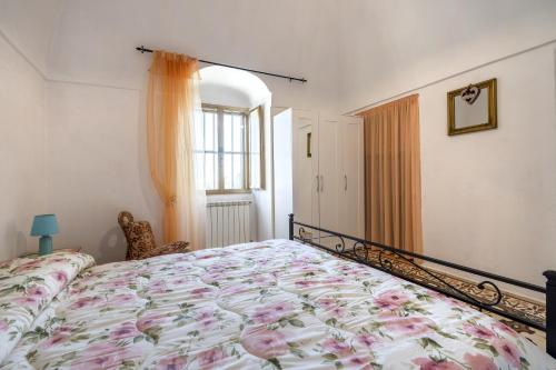 um quarto com uma cama com um edredão floral em La casa di pietra location Rosy em Monopoli