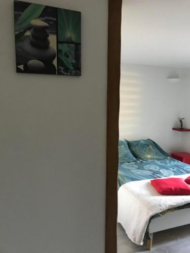 1 dormitorio con 1 cama y una pintura en la pared en Chambre indépendante privée avec salle de bain, en La Chapelle-dʼAngillon
