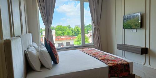 una camera da letto con un letto e una grande finestra di HHW Buddha Lineage a Varanasi