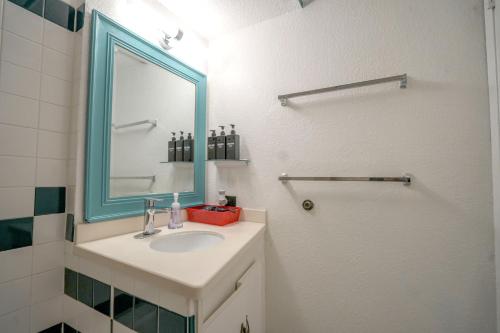 a bathroom with a sink and a mirror and a shower at Diamond, Ocean, and Canal view Affordable Family House in Honolulu
