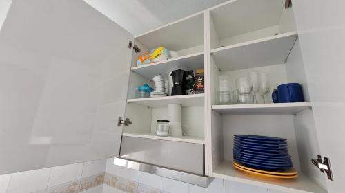 una cucina bianca con ripiani e piatti bianchi di Apartamento Lo Pagan a Lo Pagán