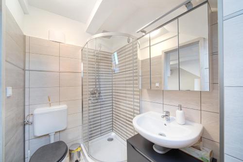 La salle de bains est pourvue d'un lavabo, de toilettes et d'un miroir. dans l'établissement Ágoston Apartman, à Pécs