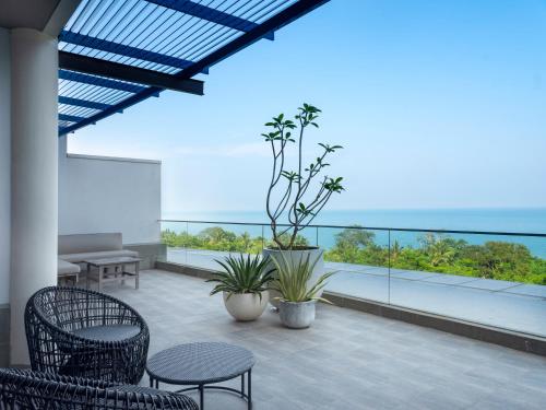 a balcony with chairs and tables and a view of the ocean at Novus Jiva Anyer in Anyer