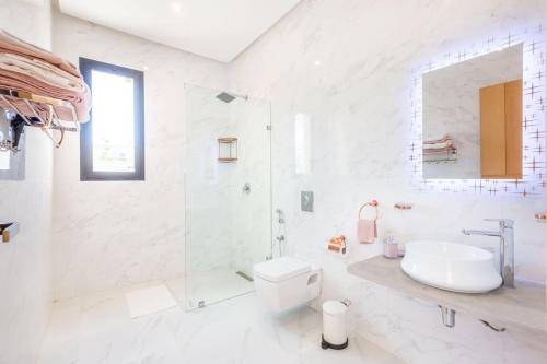 La salle de bains blanche est pourvue d'un lavabo et de toilettes. dans l'établissement Luxury stylish 3suits villa, à Marrakech