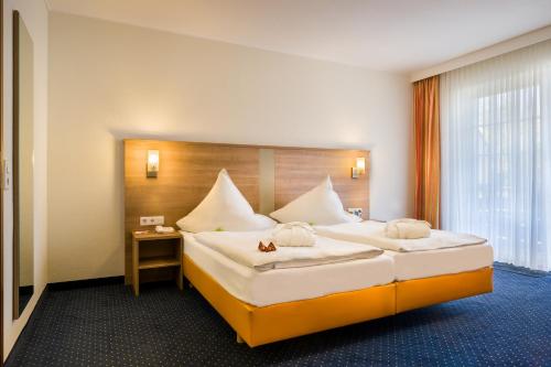 una camera d'albergo con un grande letto e una finestra di acora Düsseldorf Living the City a Dusseldorf