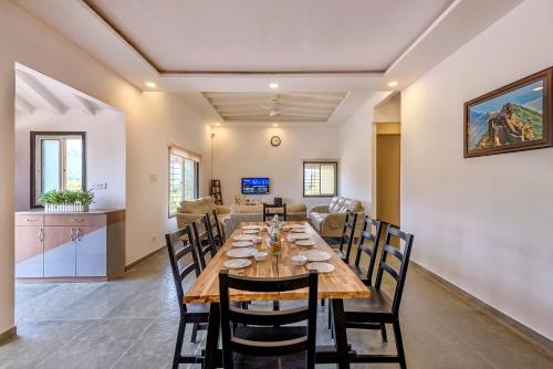 a dining room and living room with a table and chairs at CosmicStays Rajgad Vista - Stay & play: adventure awaits in Welhe