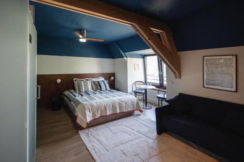1 dormitorio con 1 cama y techo azul en Café Koophandel, en Ouddorp