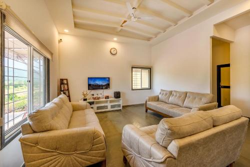 a living room with two couches and a tv at CosmicStays Rajgad Vista - Stay & play: adventure awaits in Welhe