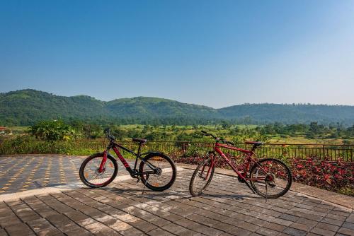 two bikes parked next to each other on a street at CosmicStays Rajgad Vista - Stay & play: adventure awaits in Welhe