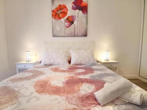 - une chambre avec un grand lit orné de fleurs rouges dans l'établissement APARTBEACH EUROPEOS 2 MUY LUMINOSO y GRAN TERRAZA, à La Pineda