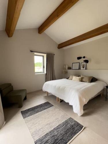 une chambre avec un lit, une chaise et une fenêtre dans l'établissement le Mas du Moulin, à Puygiron