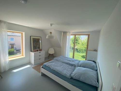 a bedroom with a bed and a large window at Modernes und Gemütliches Ferienhaus im Fichtelgebirge in Weißenstadt