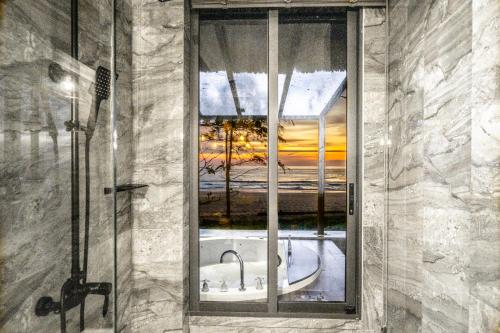 a window in a bathroom with a view of the ocean at Sealord Naithon Beachfront Villa in Nai Thon Beach
