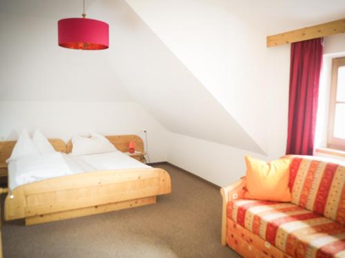 1 dormitorio con 1 cama y 1 sofá en Gasthof zum Gellnwirt, en Tamsweg