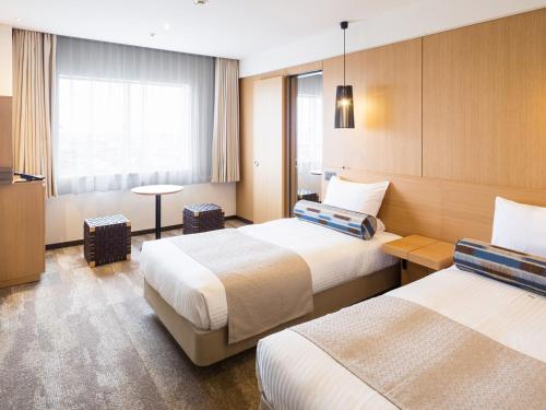 pokój hotelowy z 2 łóżkami i telewizorem w obiekcie Art Hotel Ishigakijima w mieście Ishigaki