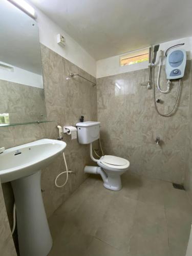 La salle de bains est pourvue de toilettes, d'un lavabo et d'une douche. dans l'établissement Lodge 87, à Negombo