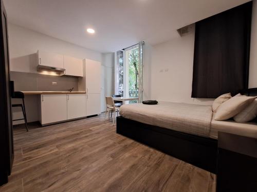 a bedroom with a bed and a kitchen with a table at Residence del Centro in Modena