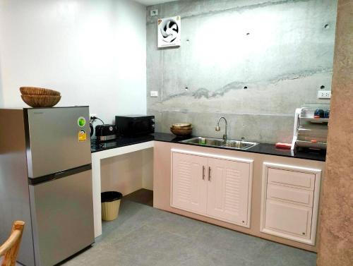 a small kitchen with a sink and a refrigerator at Grand Rock Studio Samui in Lamai