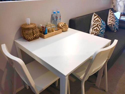 a white table with two chairs and a couch at Grand Rock Studio Samui in Lamai