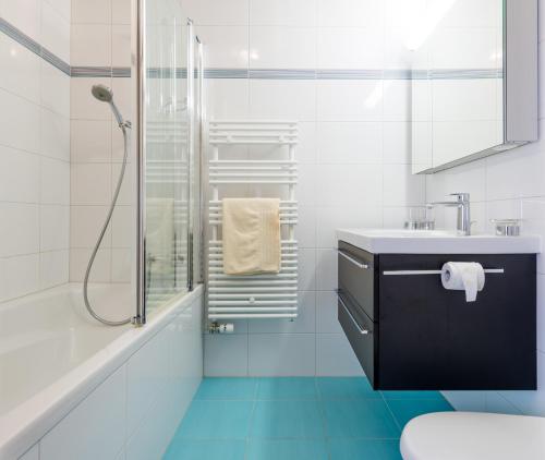 biała łazienka z umywalką i prysznicem w obiekcie Haus Alpenglück w mieście Saas-Fee