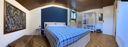 1 dormitorio con cama y pared azul en Alla Casa Medievale, en Cividale del Friuli