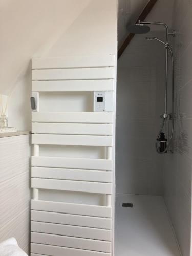 La salle de bains est pourvue de tiroirs blancs et d'une douche. dans l'établissement Les clés d'à côté - maison d'hôtes proche Rouen, à Sotteville-lès-Rouen