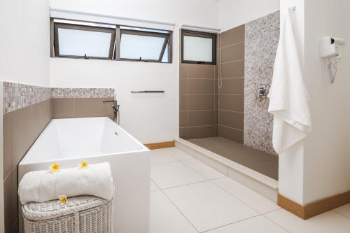 a bathroom with a tub and a shower at Latitude By Horizon Holidays in Rivière Noire