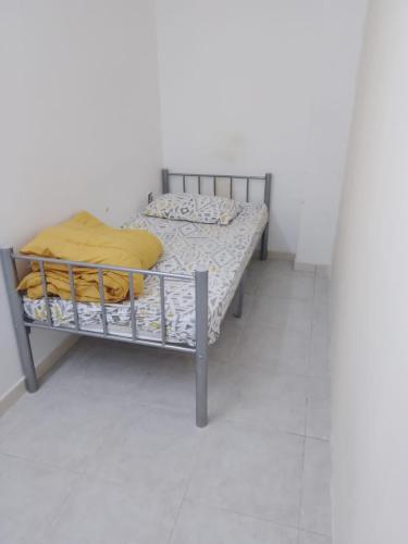 a bed with a metal frame in a room at Near Alain Main Bus stop in Mundafinah