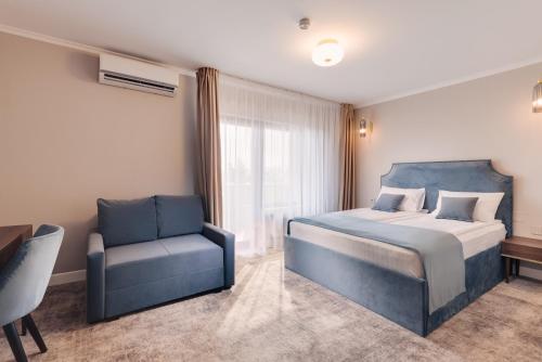 una camera con letto e sedia di Hotel Meridian a Cluj-Napoca